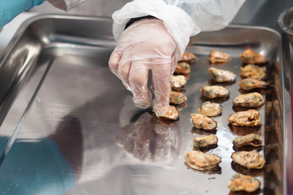 Una mano colocando productos del mar sobre una bandeja