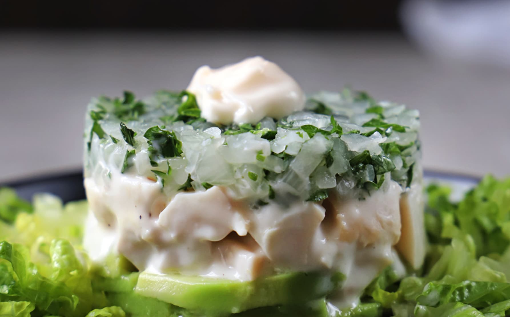 Preparación con locos y palta sobre una cama de lechugas